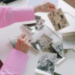An older woman sorting through old black-and-white family photographs