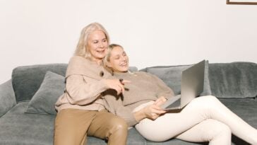Adult daughter relaxing on a couch with her mother at home