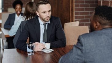 Two adults having a serious conversation over coffee in a cafe